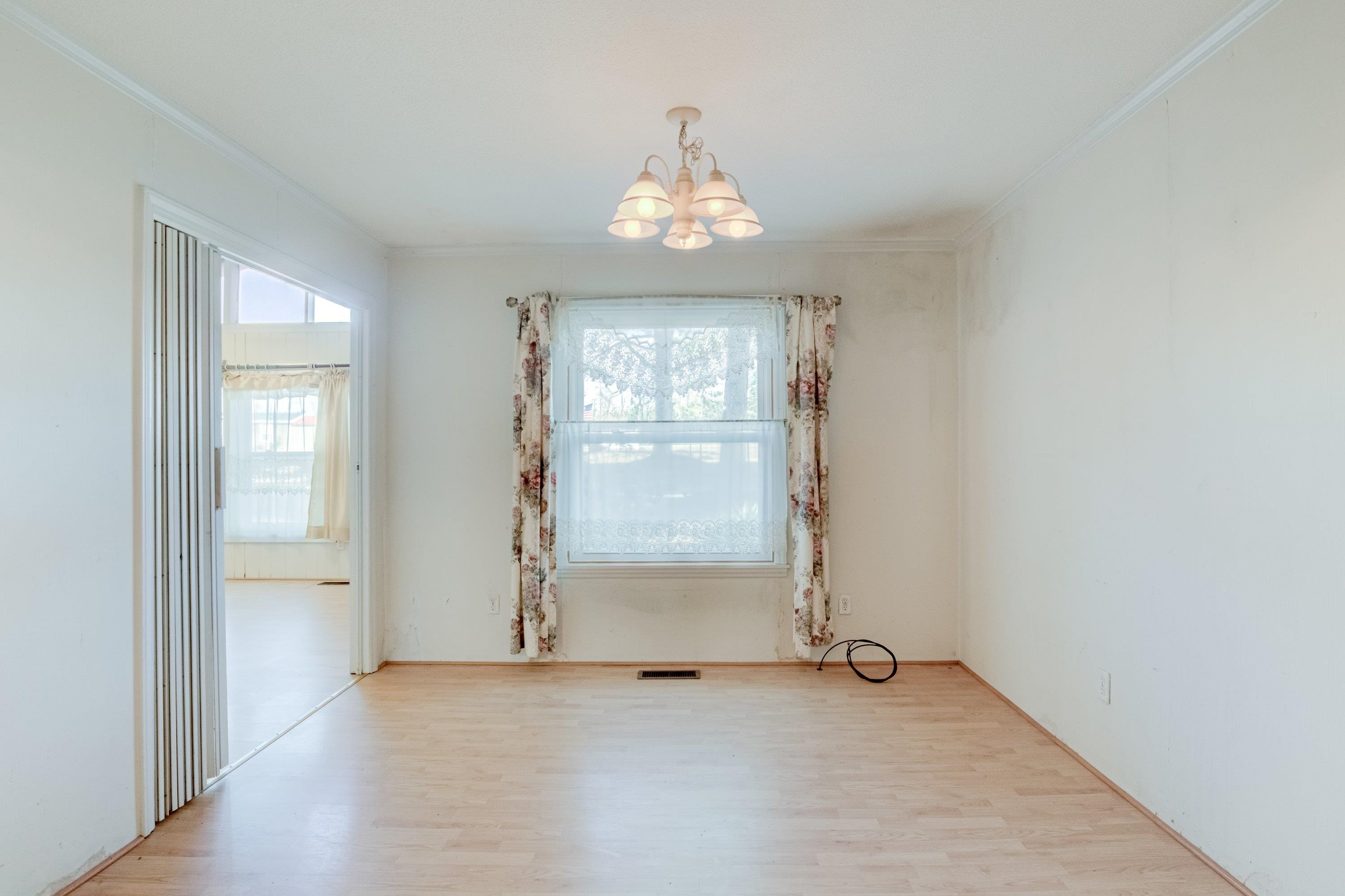 4612 Browns Pond Road Selma, NC 27576 - Photo 17 of 50 an empty room with chandelier fan and windows