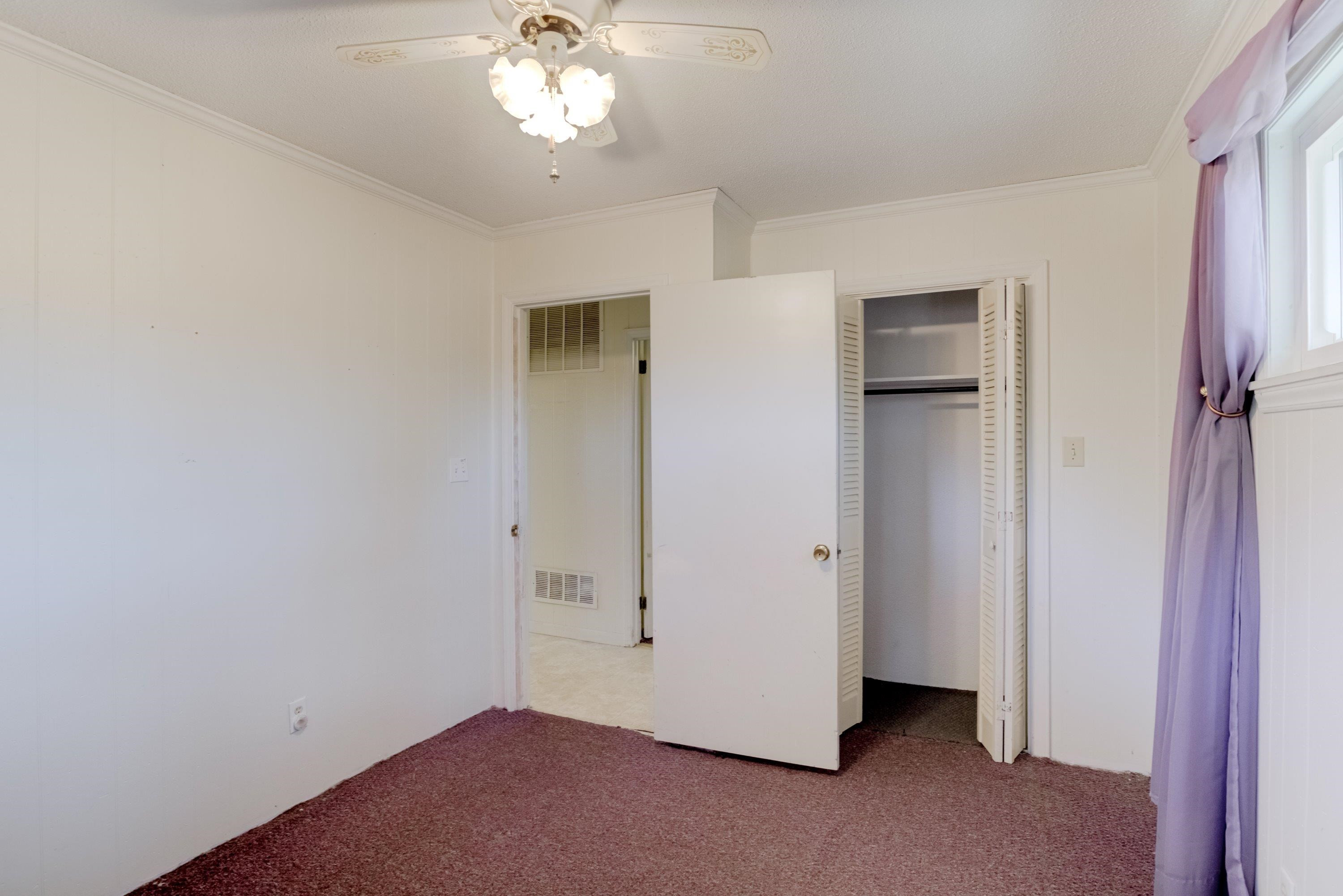 4612 Browns Pond Road Selma, NC 27576 - Photo 32 of 50 an empty room with a chandelier fan and closet area