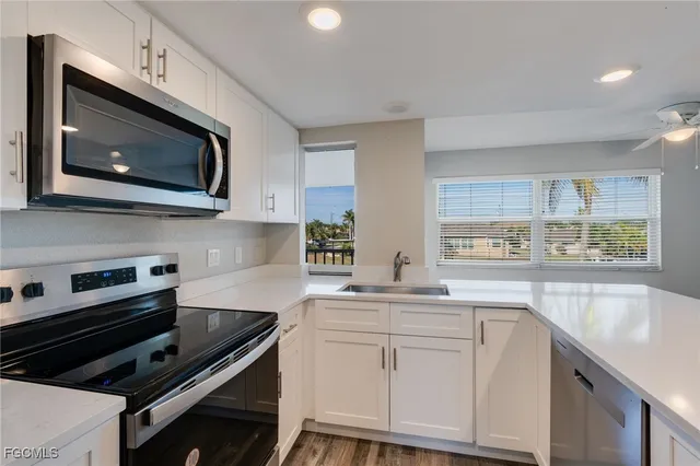 a kitchen with stainless steel appliances white cabinets and a stove top oven