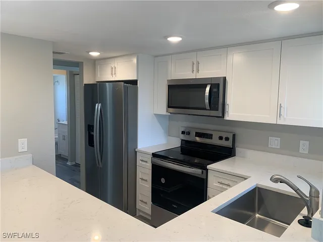 a kitchen that has a refrigerator a stove and cabinets