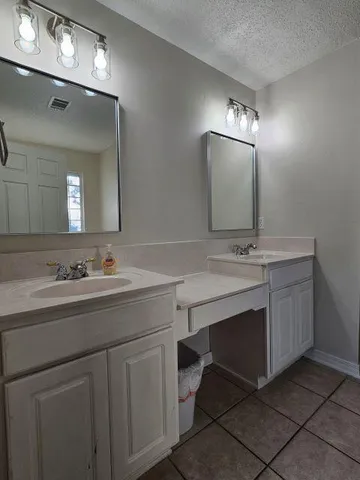 a bathroom with double sink and a mirror