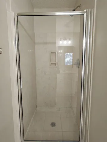a bathroom with a glass shower door