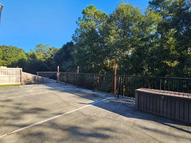 a view of backyard with small cabin and wooden fence