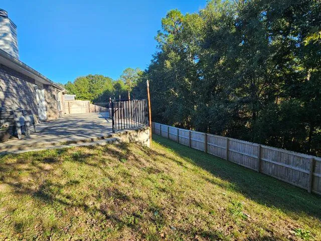 a view of a backyard with wooden fence