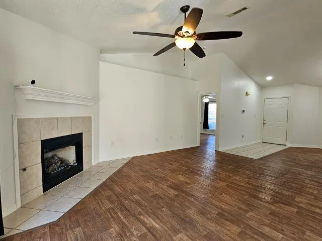 a view of empty room with wooden floor fireplace and a window
