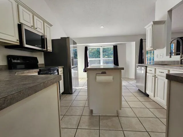 a kitchen with stainless steel appliances a stove a sink and a microwave