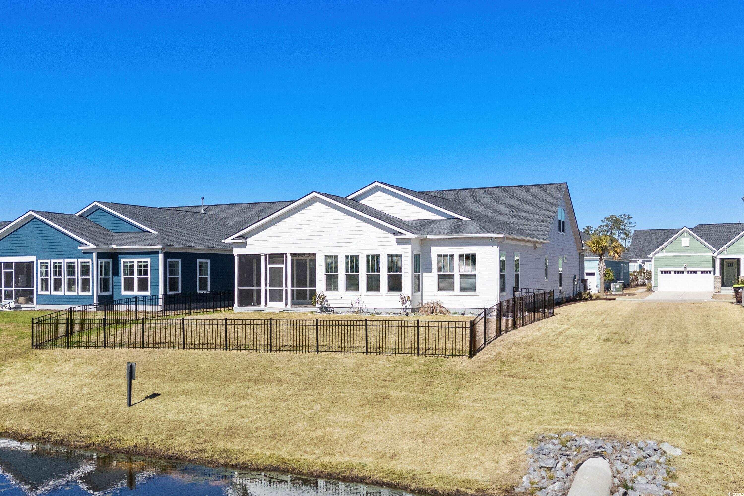 9035 Binnicker Drive Murrells Inlet, SC 29576 - Photo 5 of 40 View of front facade with a front lawn, fence, and a sunroom