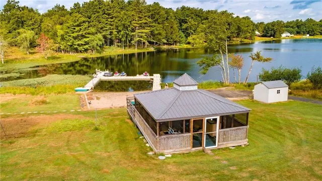 a view of a lake with chairs and table under an umbrella