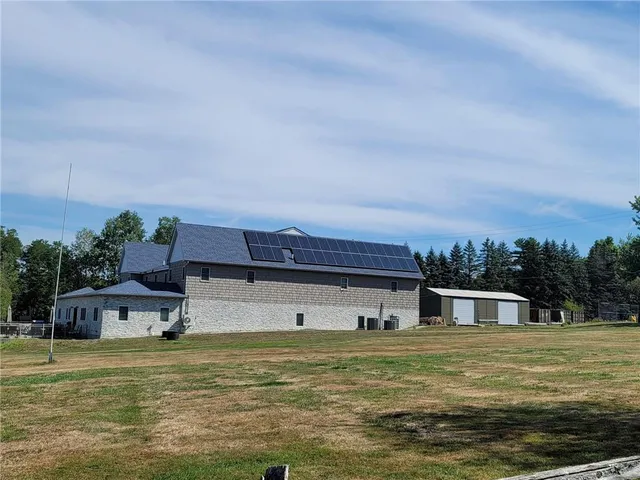 a view of a house with backyard and trees