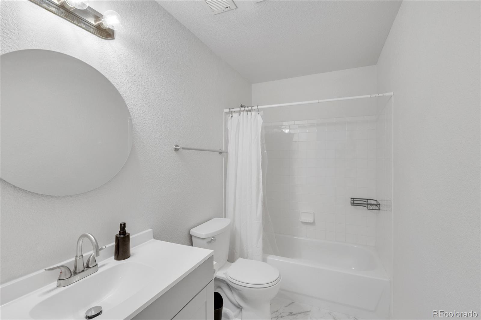 2575 South Syracuse Way, Unit G104 Denver, CO 80231 - Photo 9 of 20 a bathroom with a sink toilet and shower