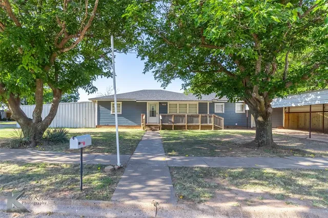 a view of a house with backyard and a tree