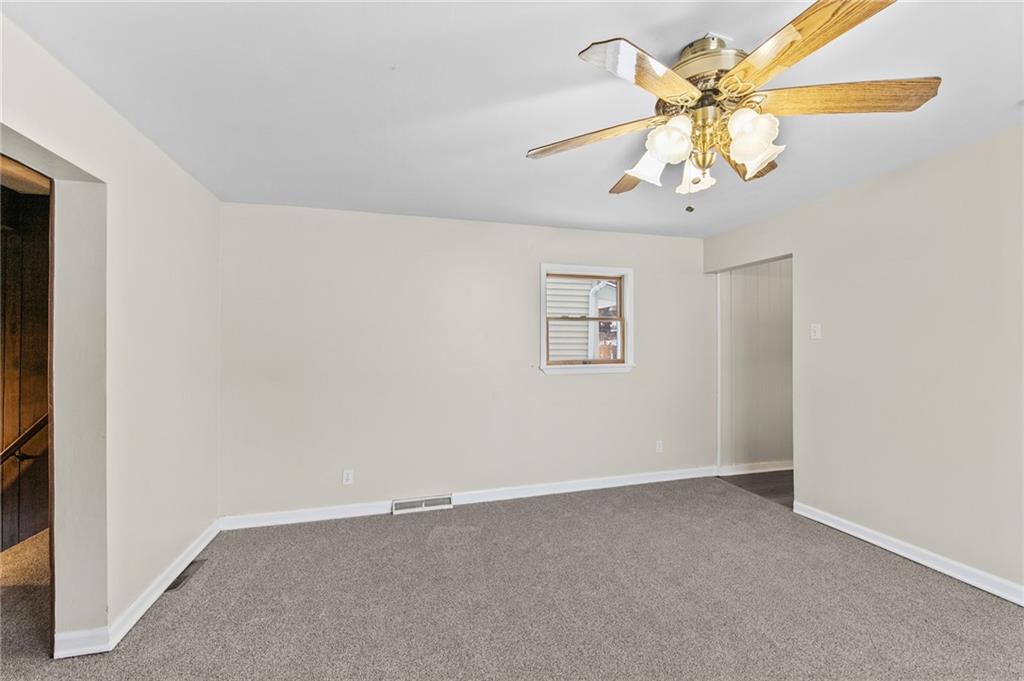 807 Oak Street Monessen, PA 15062 - Photo 5 of 28 an empty room with a chandelier fan and a chandelier fan