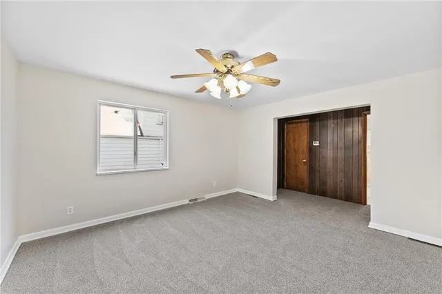 a view of a kitchen with a refrigerator a ceiling fan and wooden floor