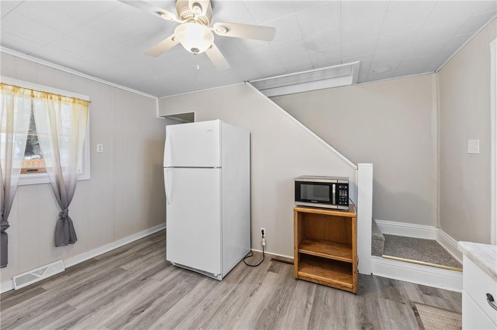 807 Oak Street Monessen, PA 15062 - Photo 7 of 28 a view of a kitchen with a refrigerator a ceiling fan and wooden floor