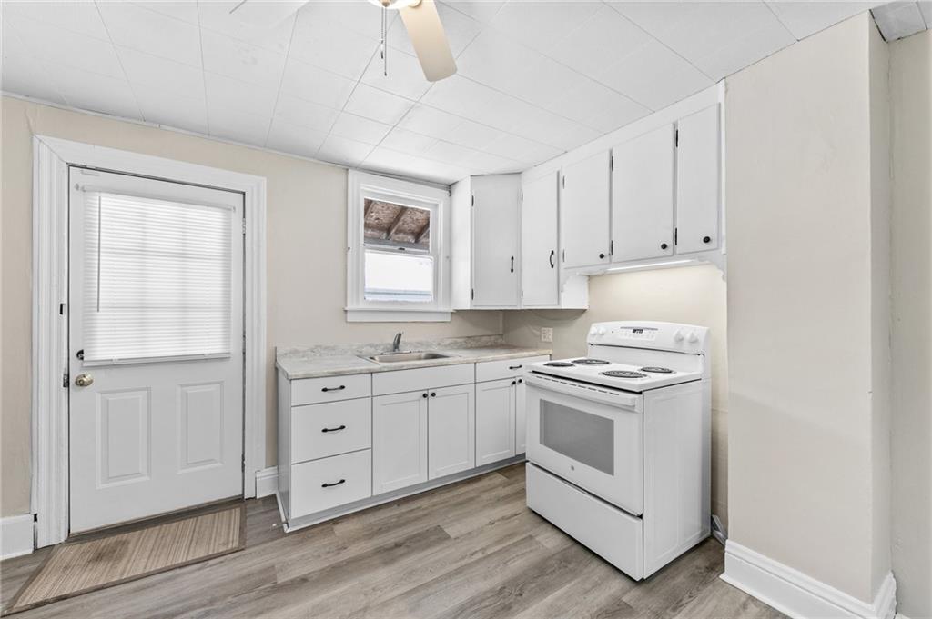 807 Oak Street Monessen, PA 15062 - Photo 8 of 28 a kitchen with granite countertop white cabinets and white appliances