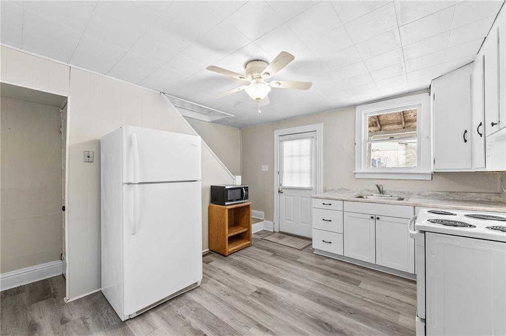 807 Oak Street Monessen, PA 15062 - Photo 9 of 28 a kitchen with white cabinets and white appliances