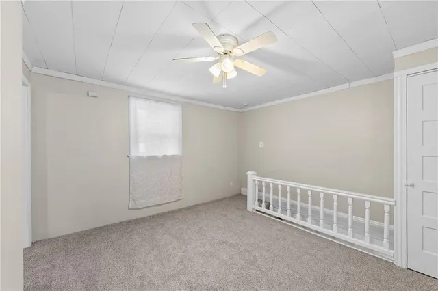 an empty room with closet and a chandelier fan