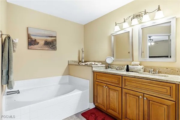a bathroom with a tub a double vanity sink and mirror