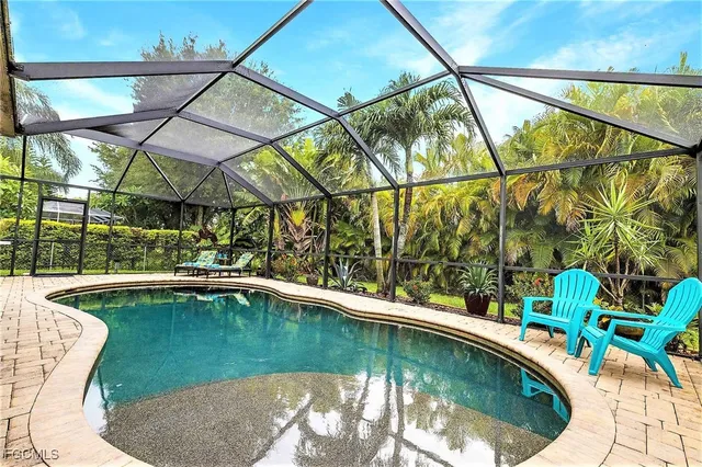 a view of a swimming pool with a yard and sitting area