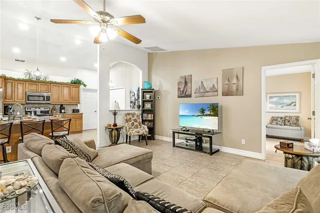 a living room with furniture kitchen view and a large window