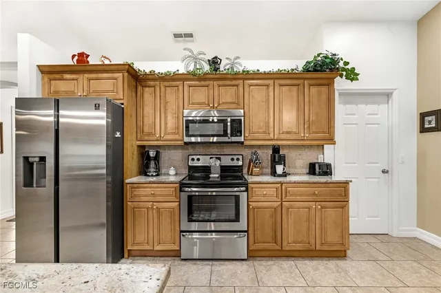 a kitchen with granite countertop a stove top oven and cabinets