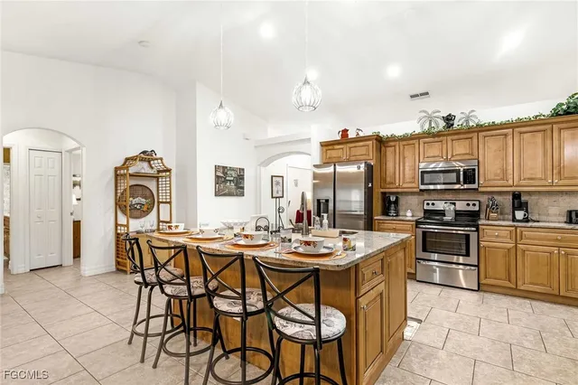 a kitchen with stainless steel appliances a table and chairs in it