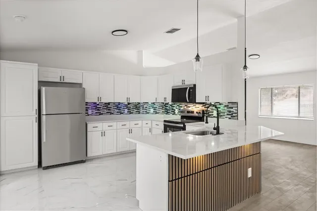 a kitchen with white cabinets and refrigerator