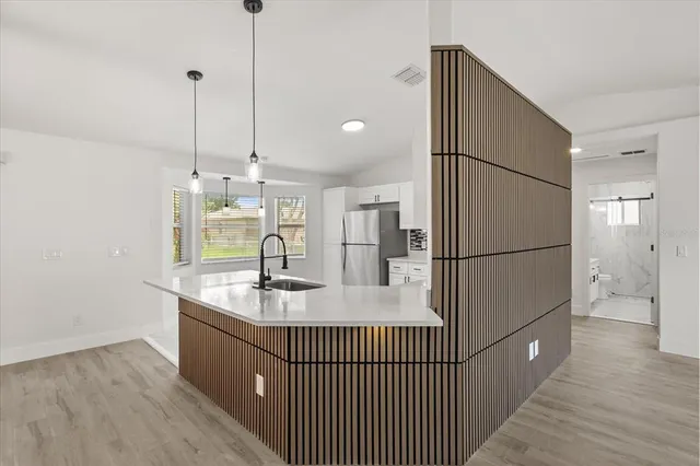 a kitchen with kitchen island a counter top space a sink and refrigerator