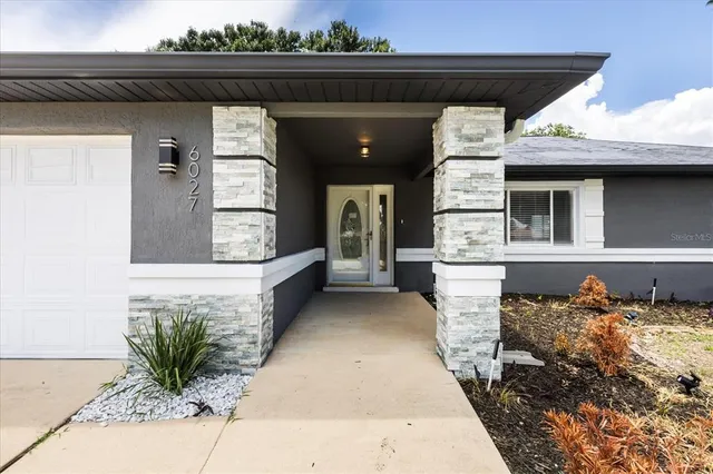 a front view of a house with potted plants