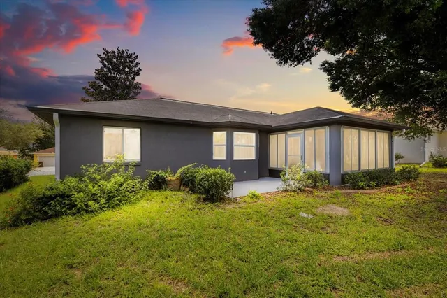 a view of a house with backyard and tree