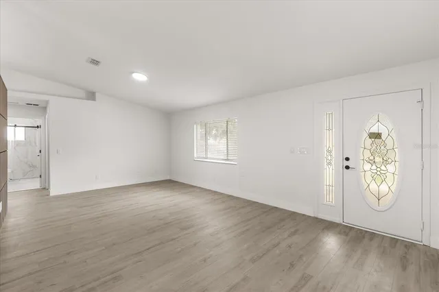 an empty room with wooden floor and mirror