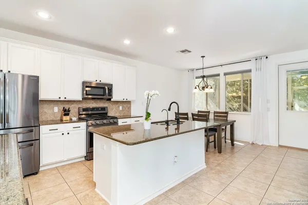 a kitchen with appliances a sink a counter top space and cabinets