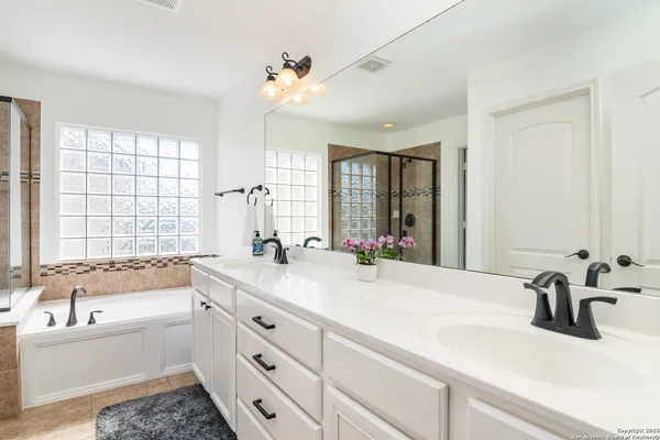 a bathroom with a tub sink and mirror