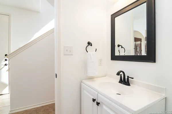 a bathroom with a sink and mirror with window
