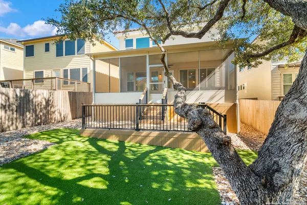 a view of a house with a small yard and wooden fence