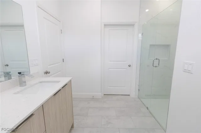 a bathroom with a sink a mirror and a shower