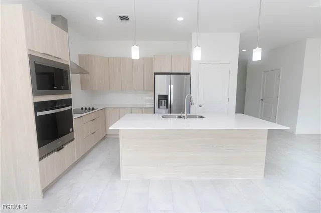 a view with granite countertop kitchen island a sink stainless steel appliances and cabinets
