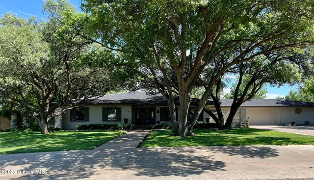 a front view of a house with a yard and an trees