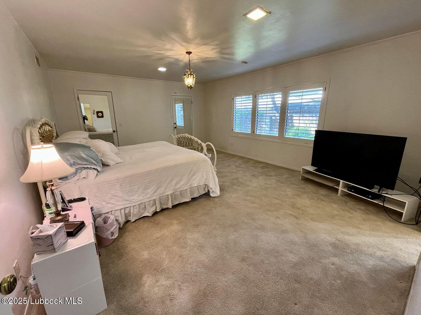 103 Yucca Terrace Plainview, TX 79072 - Photo 23 of 79 a spacious bedroom with a bed and a flat screen tv