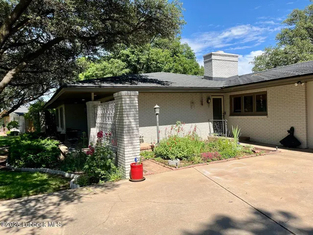 a front view of a house with a yard and potted plants
