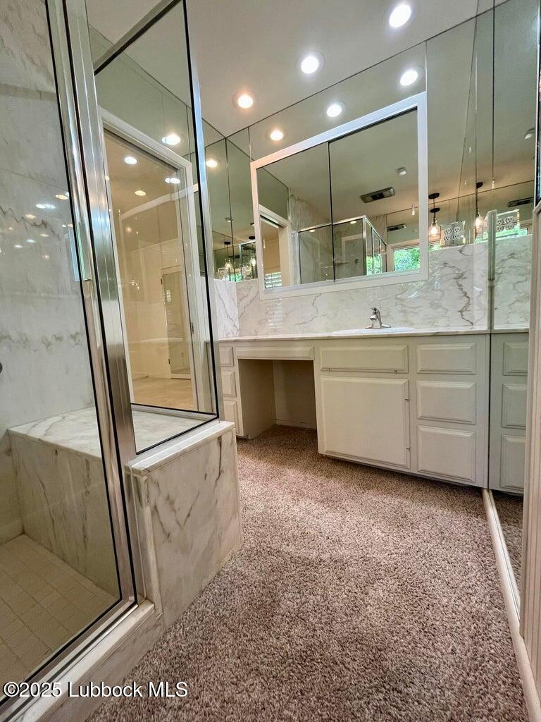 103 Yucca Terrace Plainview, TX 79072 - Photo 48 of 79 a bathroom with a double vanity sink a mirror and a shower
