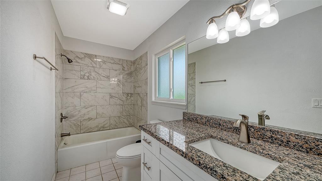 972 Leeward Road Venice, FL 34293 - Photo 17 of 27 a bathroom with a granite countertop sink a toilet and shower