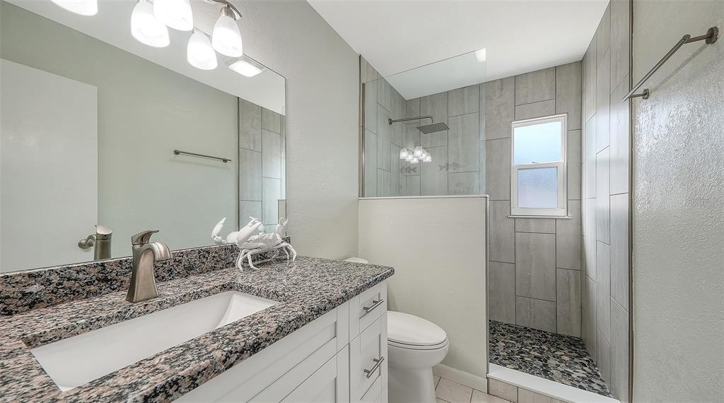 972 Leeward Road Venice, FL 34293 - Photo 19 of 27 a bathroom with a granite countertop sink a toilet and shower