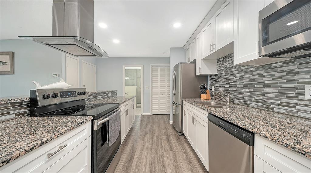 972 Leeward Road Venice, FL 34293 - Photo 10 of 27 a kitchen with stainless steel appliances granite countertop a sink and stove