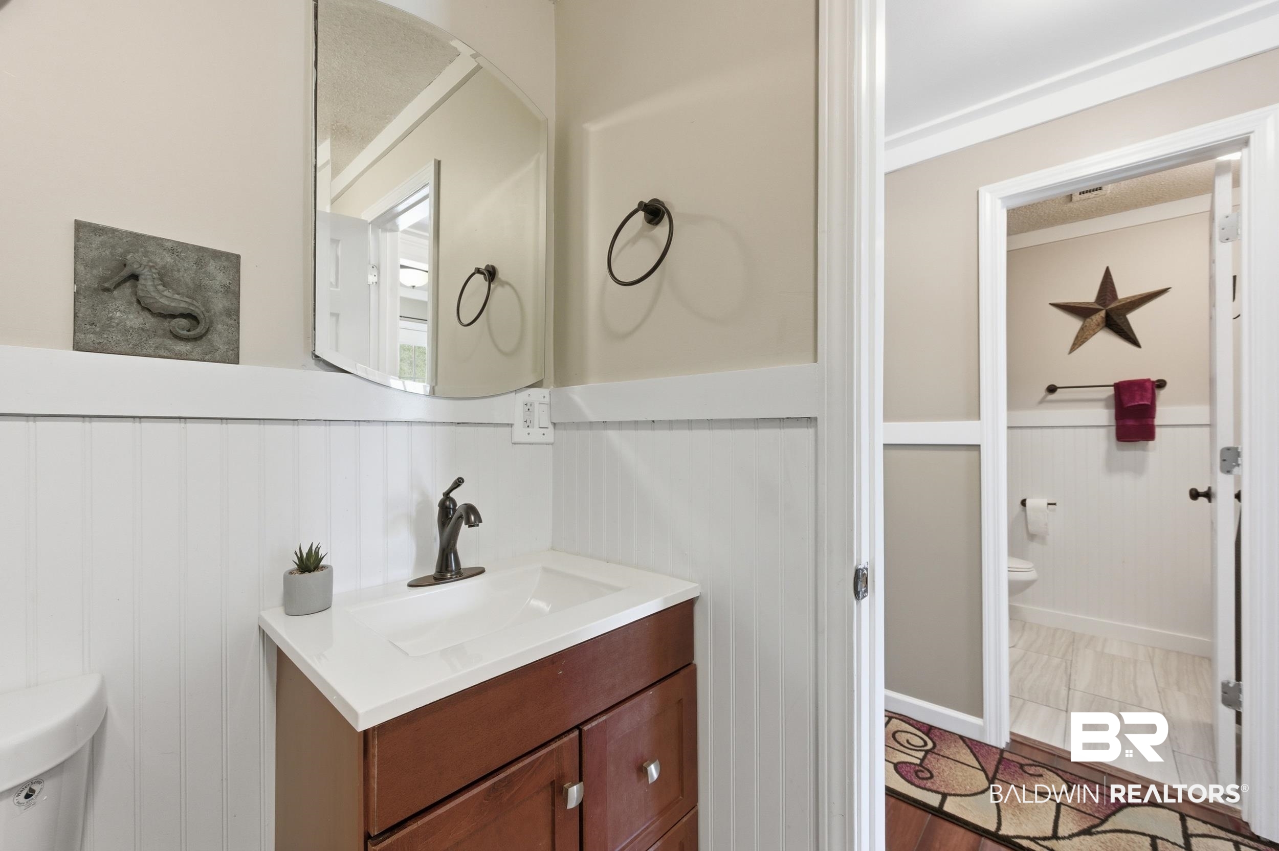 51620 Robert White Road Bay Minette, AL 36507 - Photo 53 of 81 Bathroom vanity with wood-finish cabinetry, a white countertop, and a dark bronze-finish faucet