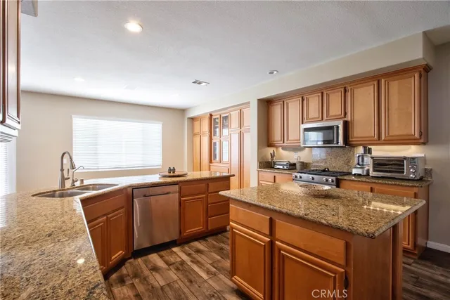 a kitchen with stainless steel appliances granite countertop a sink stove and microwave
