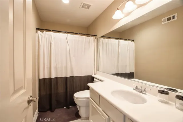a bathroom with a sink a toilet and shower curtain