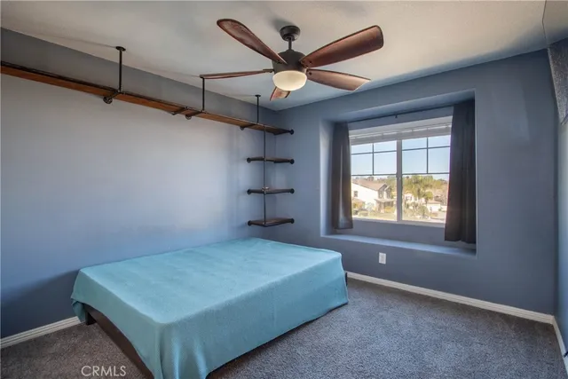 a bedroom with a bed and a ceiling fan