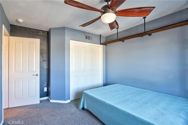 an empty room with closet and fan