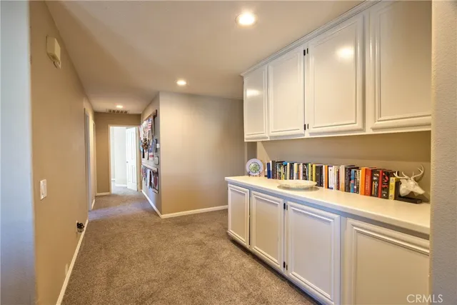 a view of a kitchen with furniture and white cabinets